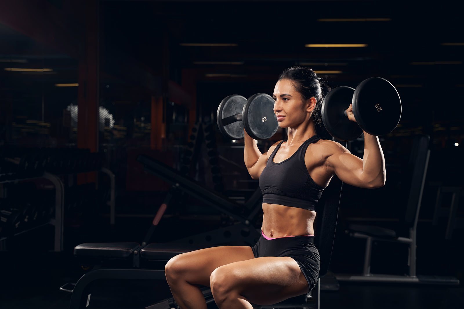 Spor salonunda dumbbell tutan kadın sporcu