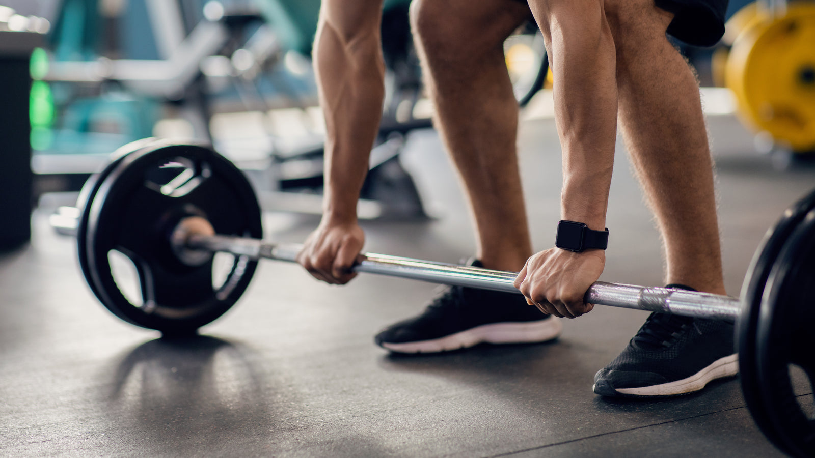Spor salonunda halterle çalışan sporcu