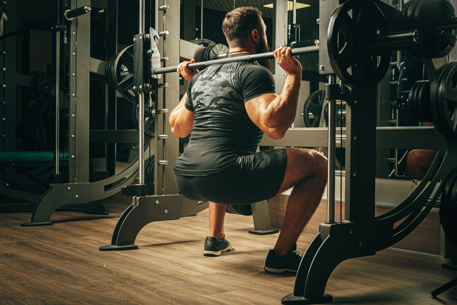 Makinede squat çalışan sporcu