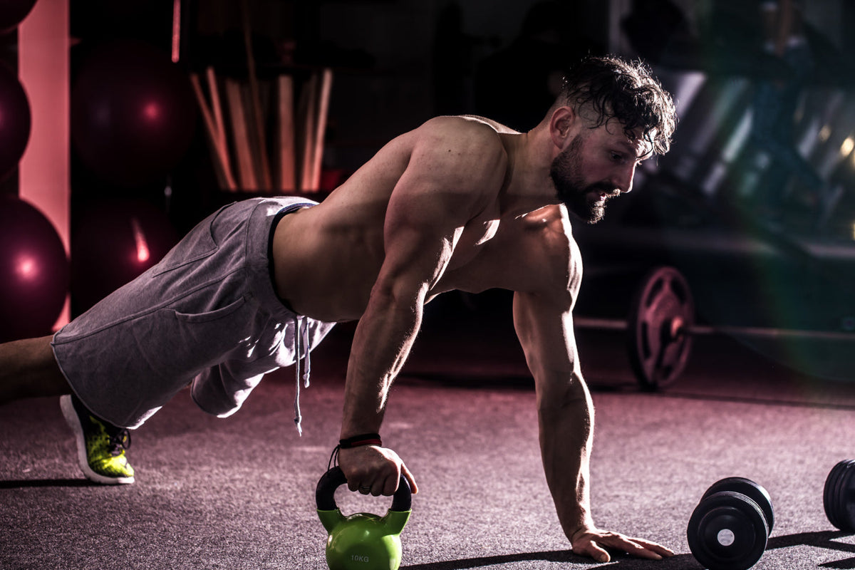 Kettlebell üzerinde şınav çeken sporcu