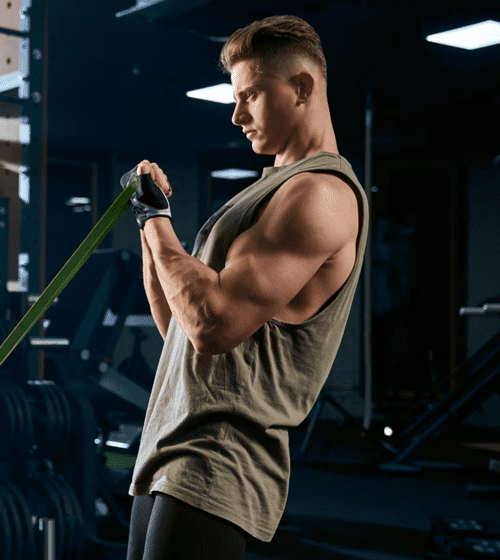 Spor salonunda direnç bandıyla biceps çalışan sporcu