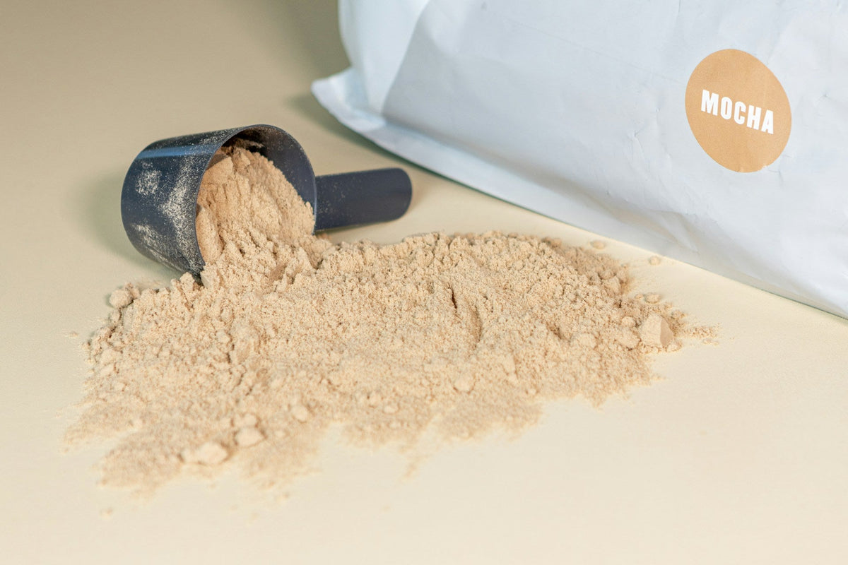 Mocha aromalı protein tozu, ölçek kaşığı ve ambalajıyla birlikte